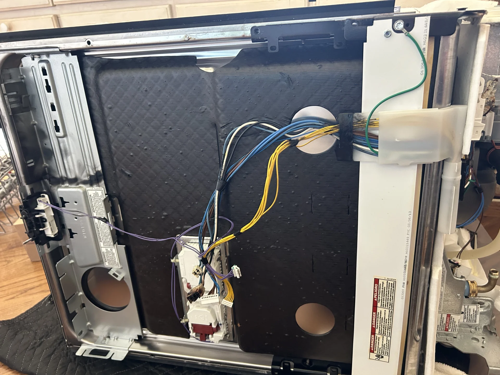 TI Constant Inc. technician repairing internal components of KitchenAid dishwasher