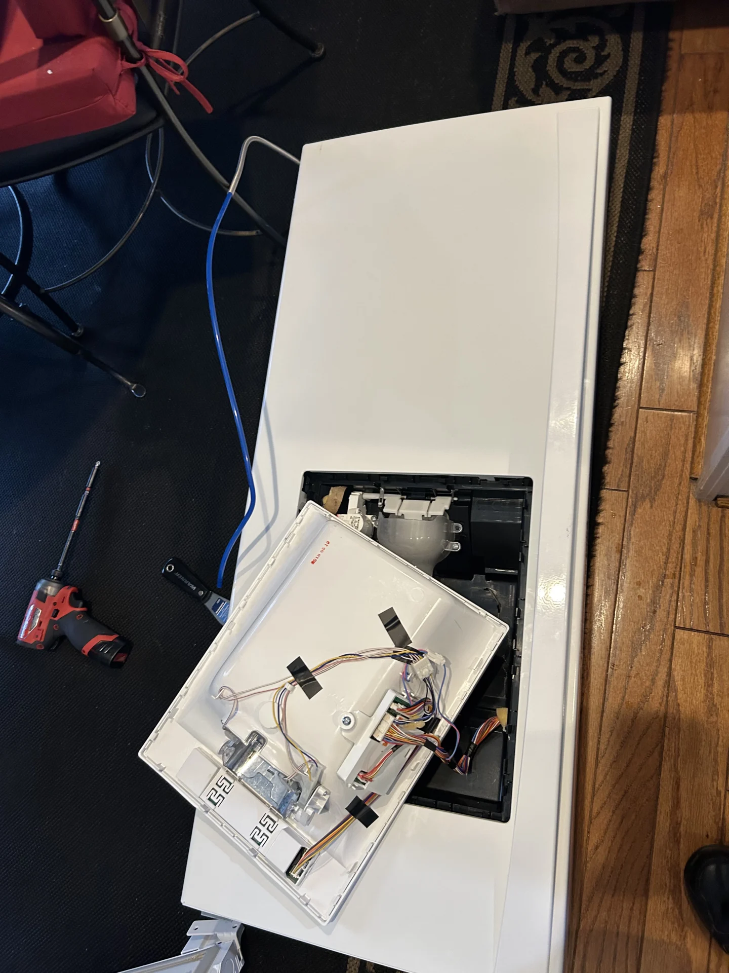 Technician reconnecting water valves during LG refrigerator door replacement